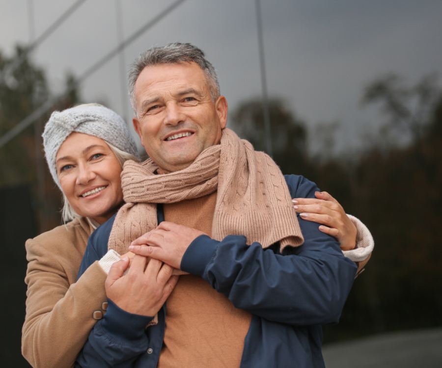 Un couple d’âge mûr à l’extérieur, en manteaux d’automne